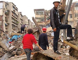 Fu Guanyu, in red, watched rescuers search the wrecked apartments. She allowed NPR to observe the operation and her discovery that her toddler son had died in the arms of his grandfather. (Photo: Andrea Hsu.)