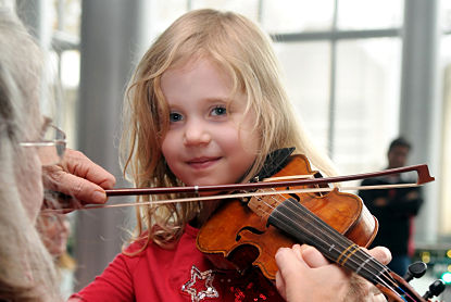 In this 2012 photo from an Instrument Petting Zoo hosted by Seattle's KING-FM, a girl learned how to hold a violin. Photo: Jack Storms