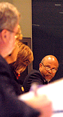 Wilson peers over his eyeglasses at Tomlinson in foreground